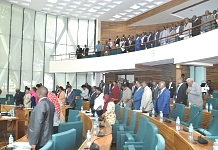 The Members stand for the Parliamentary Prayers at the Start. On the balcony are members of the public and visitors who were in attendance