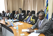 Speaker of EALA, Rt Hon Ngoga Martin (second right),clerks at table, Victor Manzi and Wimile Asheri and Council to the Community, Anthony Kafumbe pay attention to the virtual session