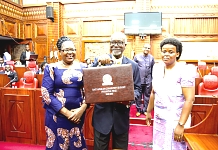 The Chair of the EAC Council of Ministers, Hon Dr Ali Kirunda Kivenjija holds aloft the Budget briefcase.  He is flanked by the Deputy Minister for Foreign Affairs and EAC Co-operation, United Republic of Tanzania, Hon Dr Susan Kolimba and the Minister of